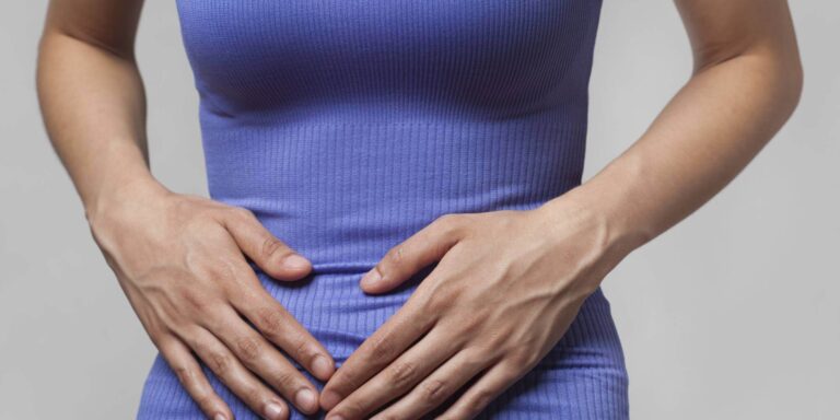 A person holding their hands on their stomach.